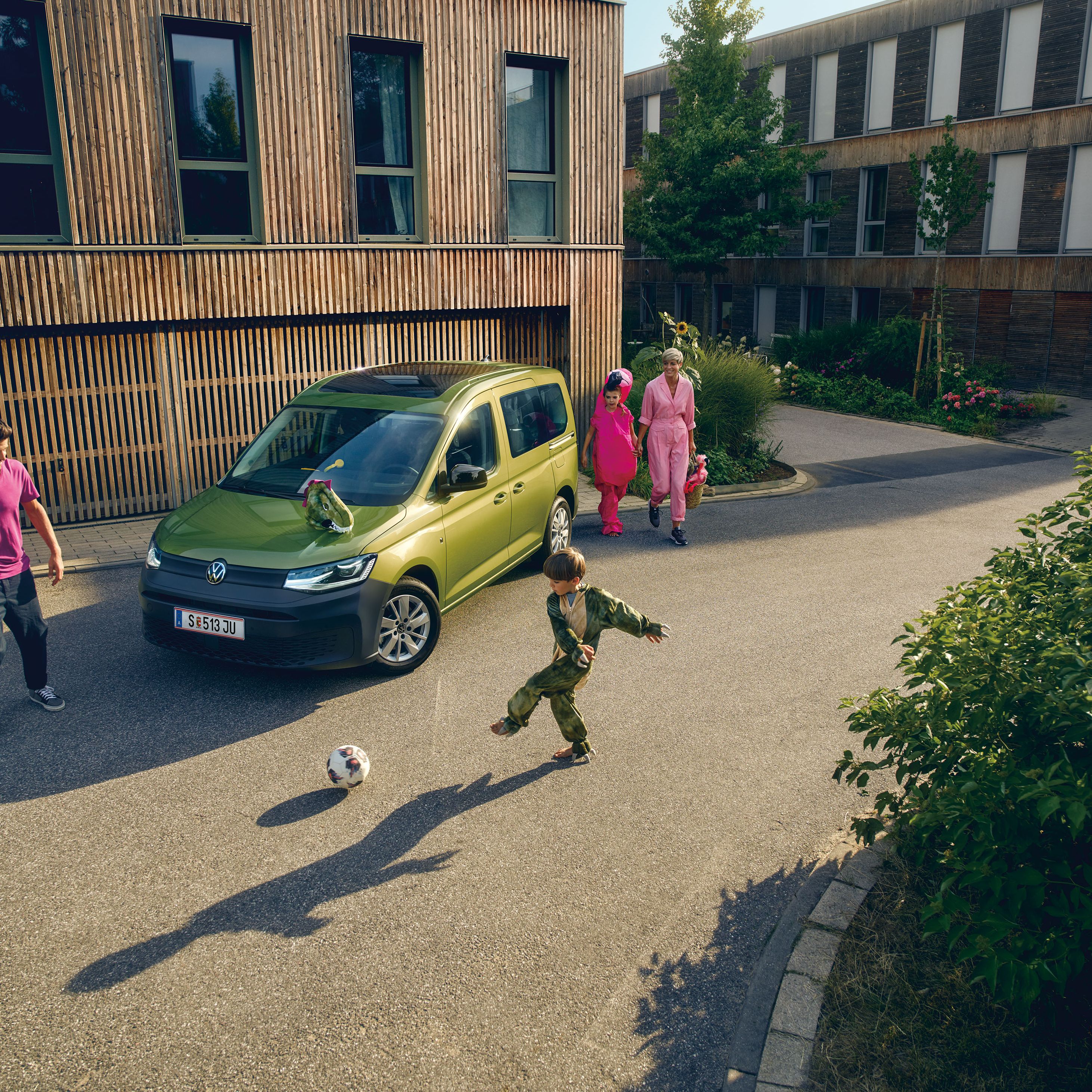 Grüner VW Caddy mit Familie