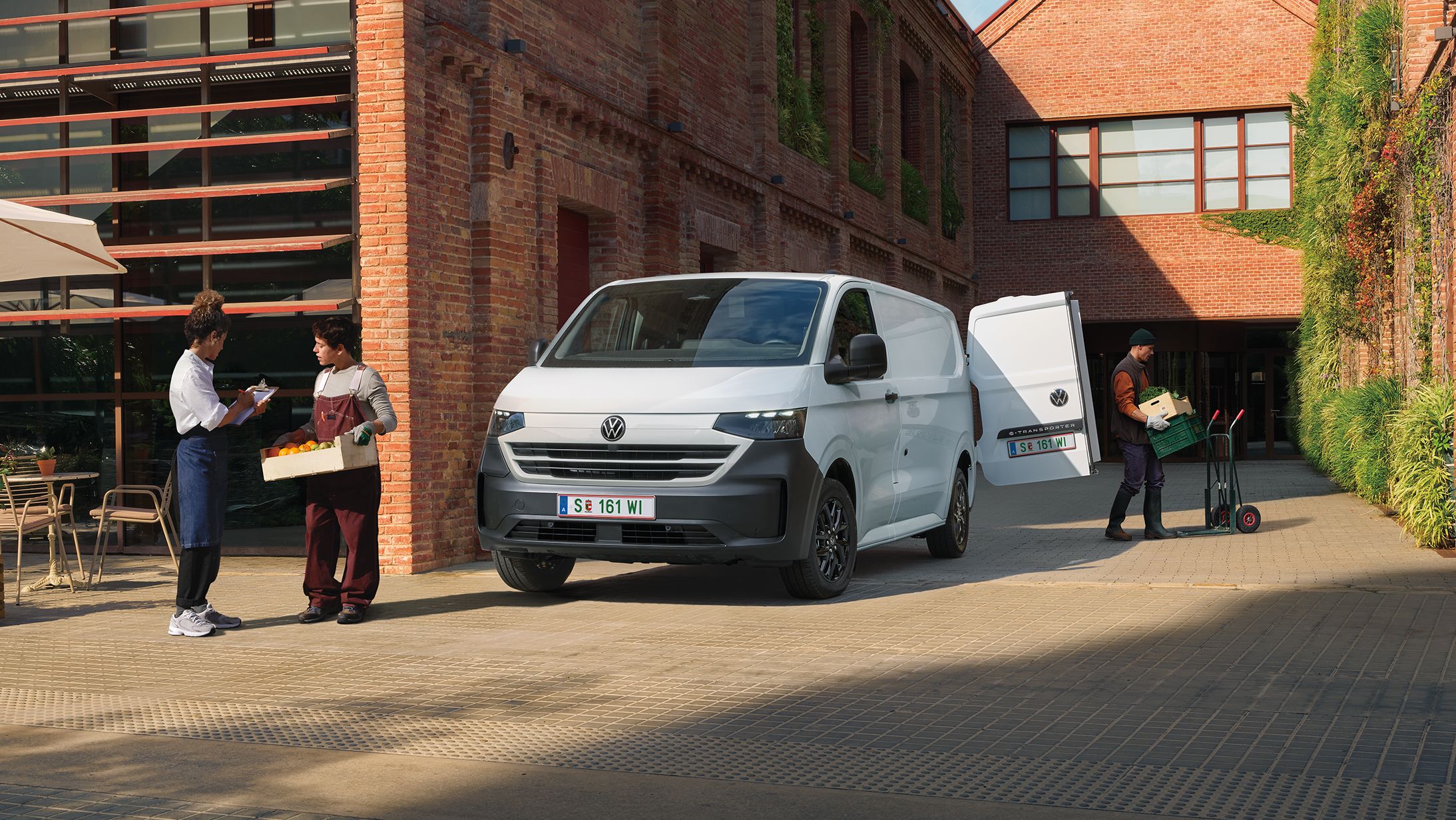 VW Transporter Kastenwagen in Weiß steht vor Haus