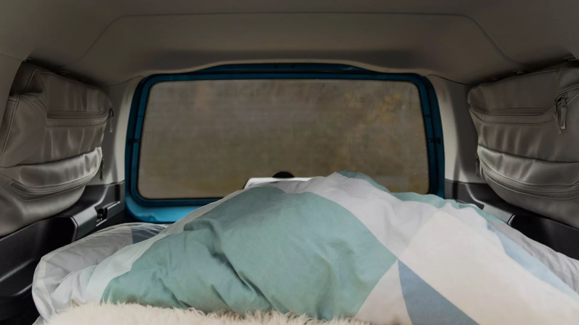 VW Caddy California verdunkelte Scheibe mit Innenraum und bezogenem Bett 