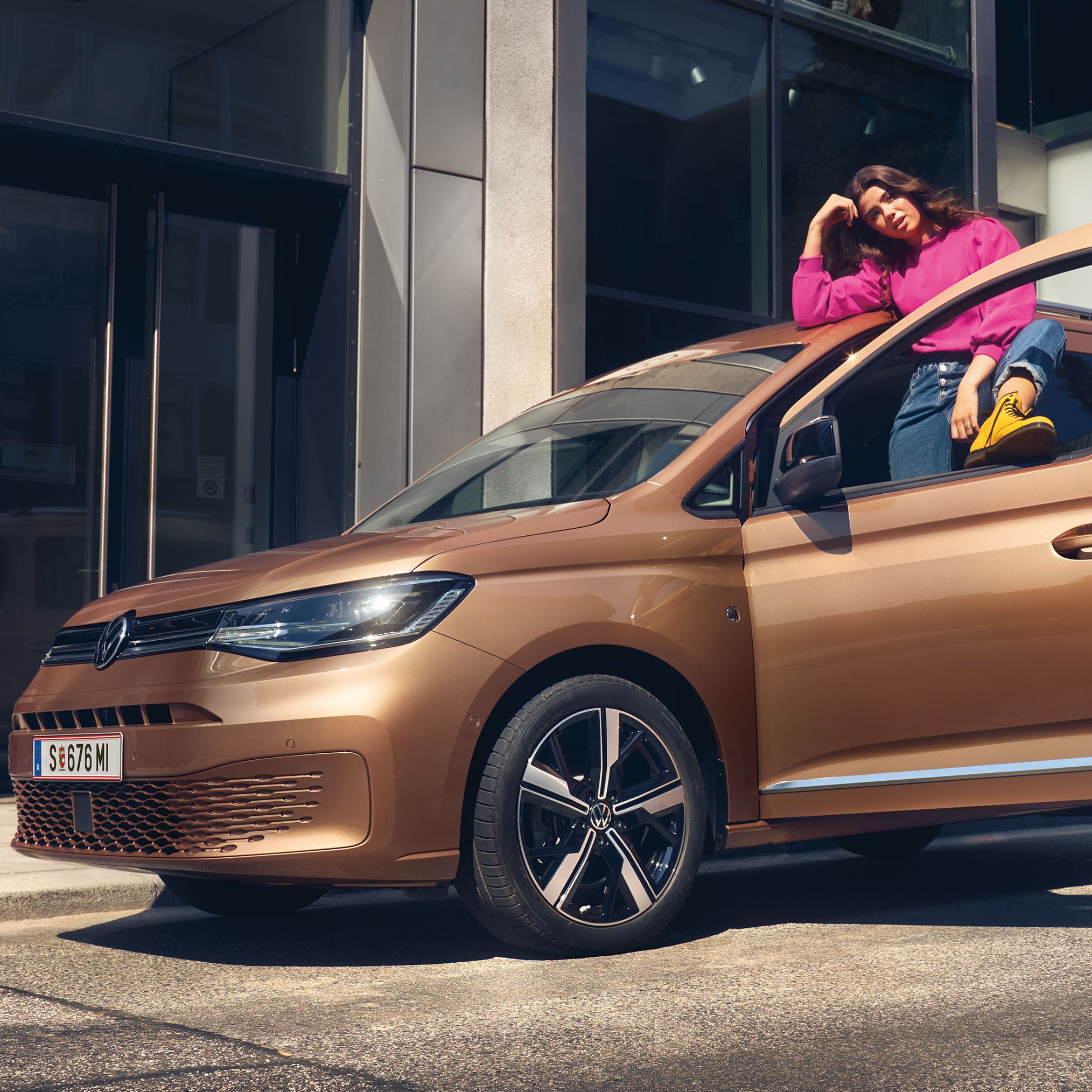 Ein VW Caddy in Copper Bronze steht auf Straße