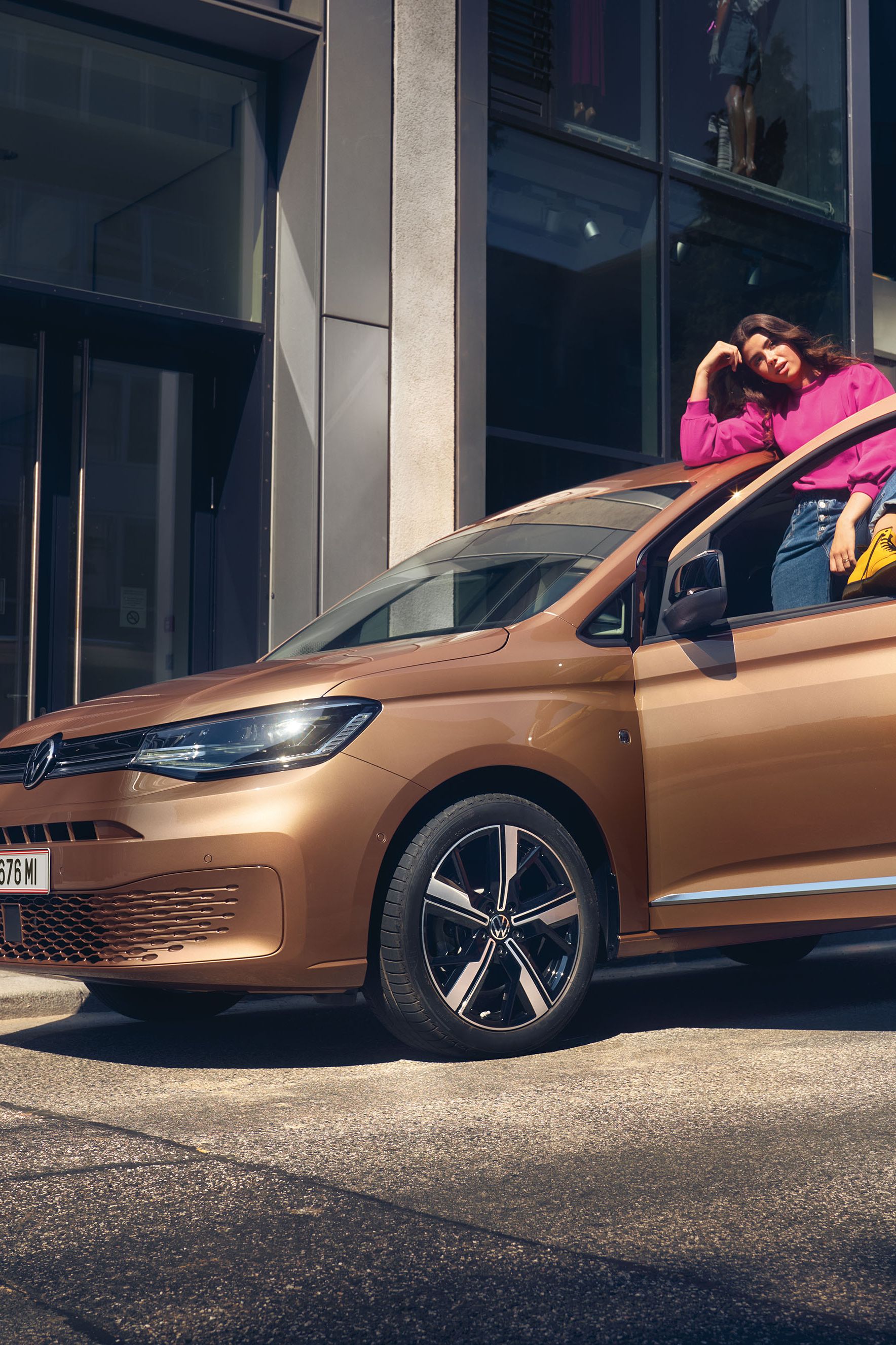 Ein VW Caddy in Copper Bronze steht auf Straße