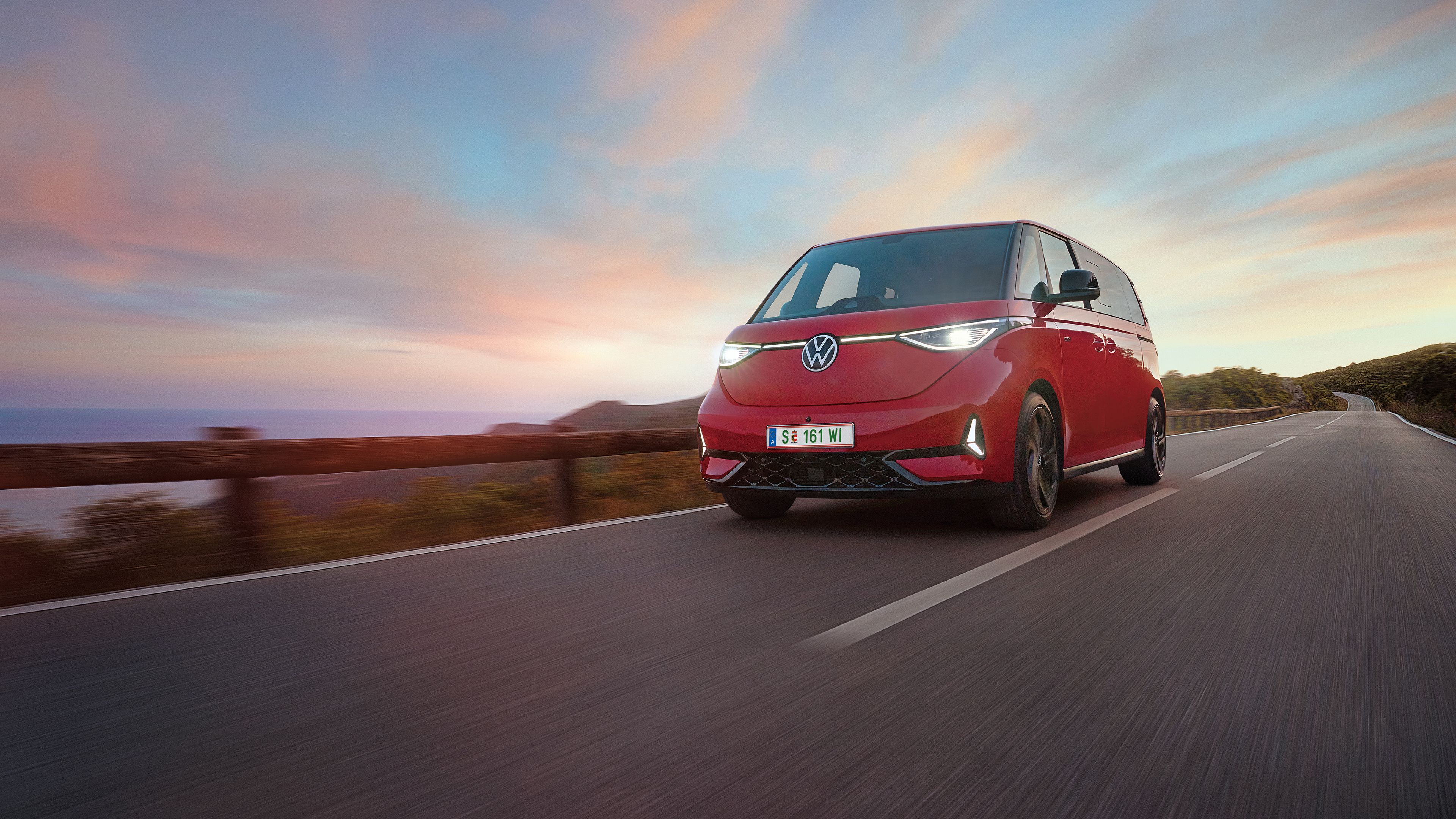 Ein roter ID. Buzz fährt entlang einer Straße in den Bergen