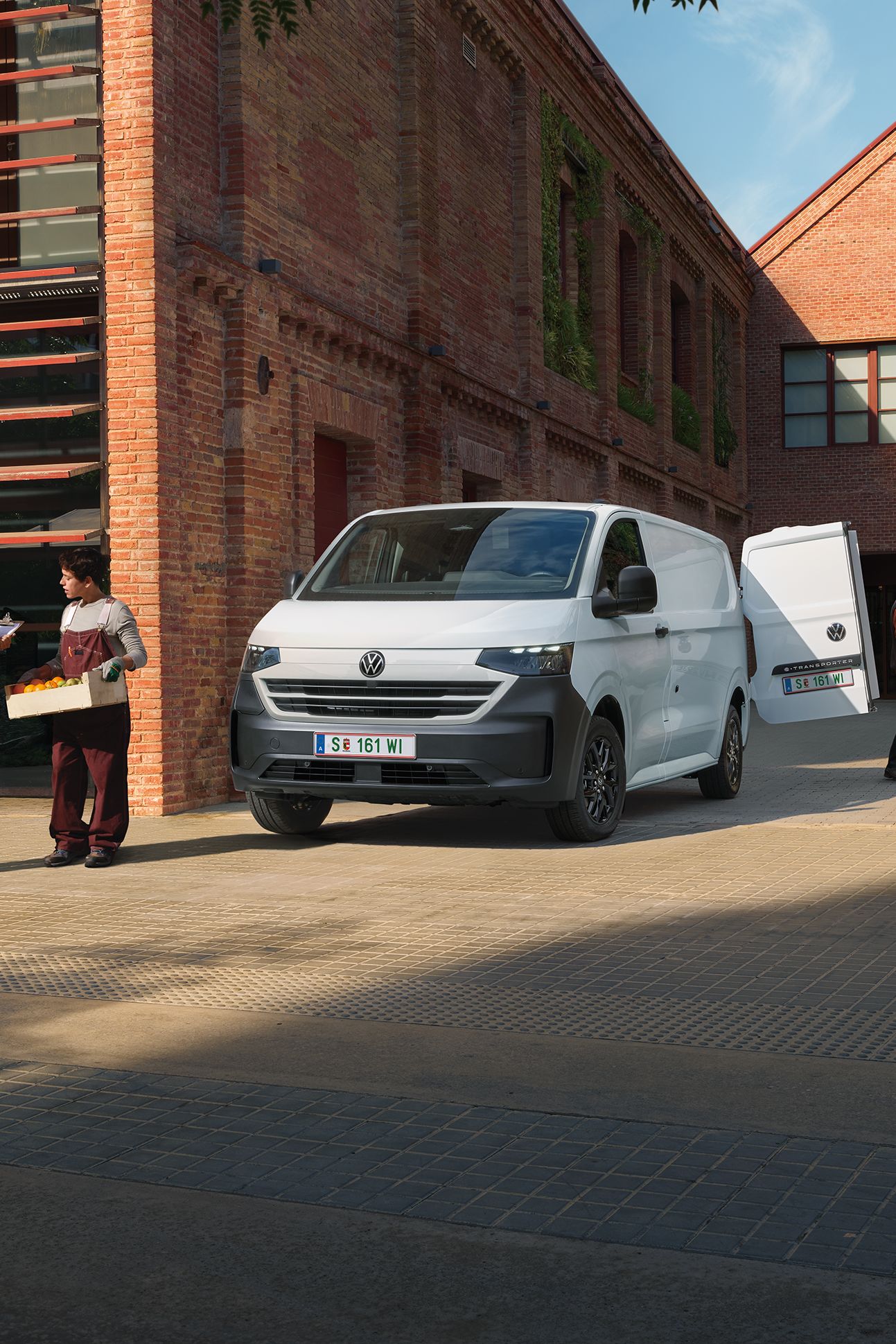 VW Transporter Kastenwagen in Weiß steht vor Haus