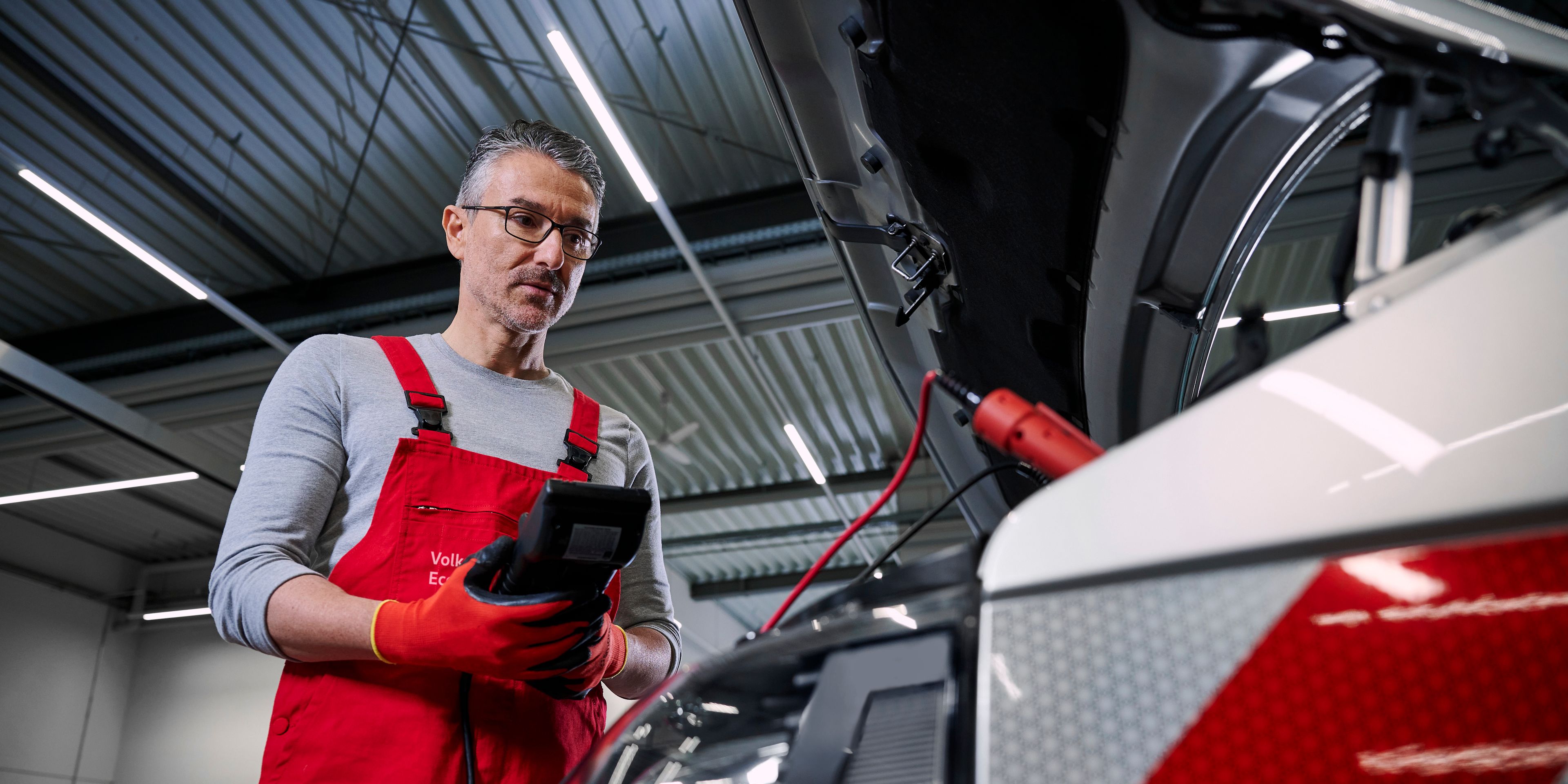 Ein Volkswagen Mechaniker überprüft die Batterien eines Volkswagen