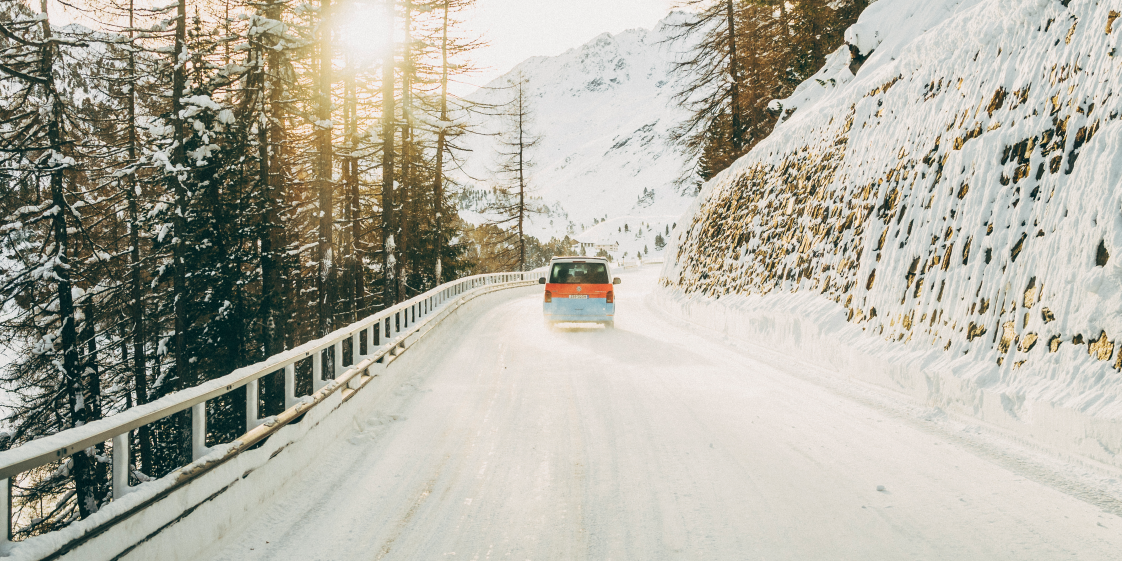 Ein Volkswagen Nutzfahrzeug fährt eine winterliche Straße entlang