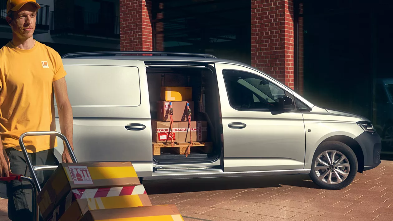 Mann entlädt einen silbernen Caddy Cargo