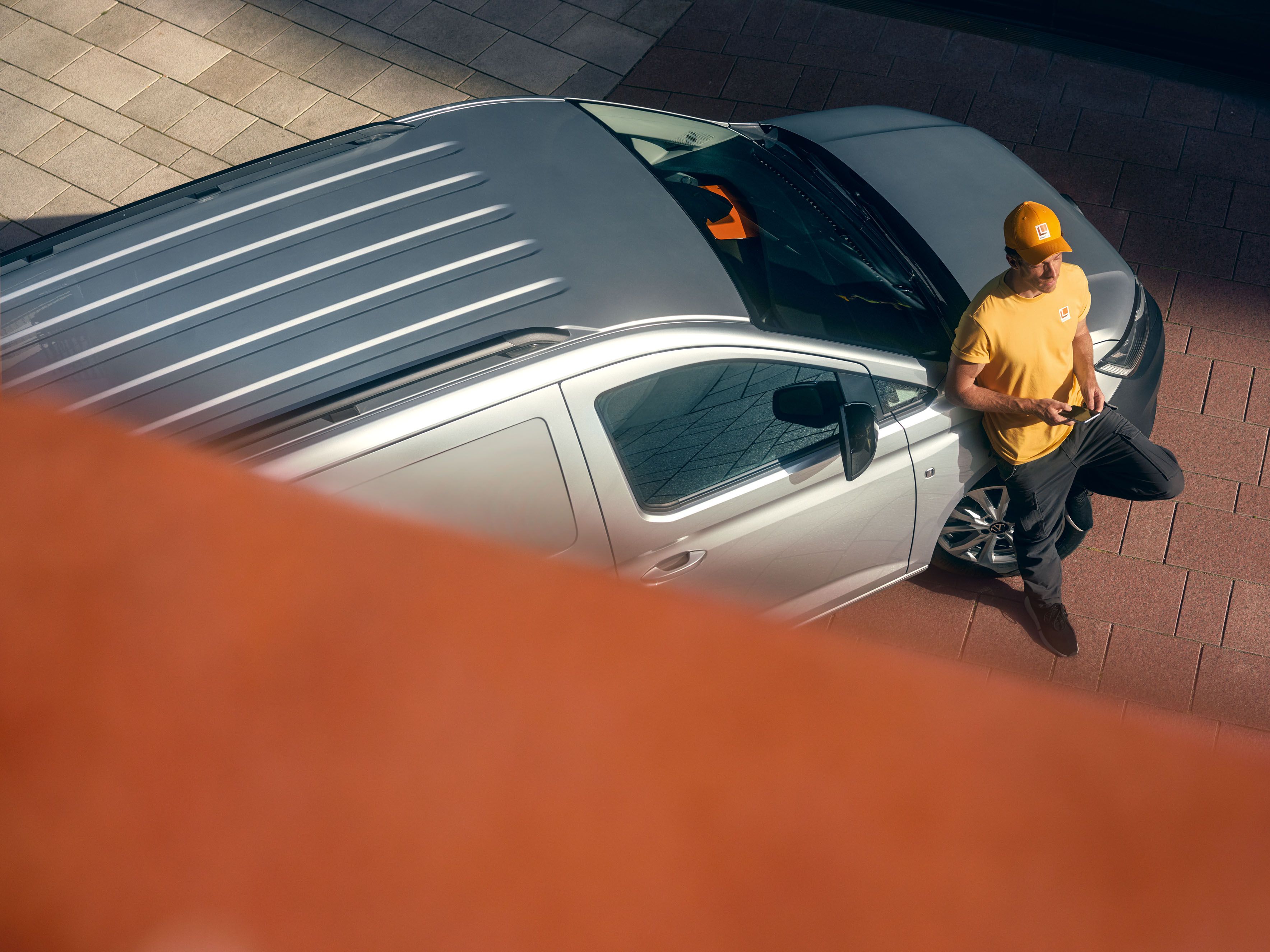 Mann lehnt an einem silbernen Caddy Cargo Maxi.